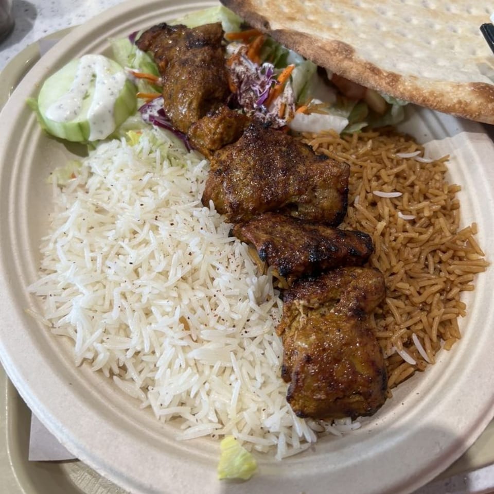 Grill Kabob plate with chicken kebab, white rice, brown rice, salad, and flatbread.
